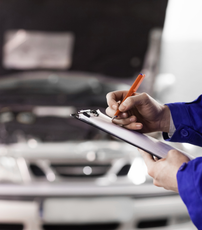 Close up of a man writing on a clipboard in a garage